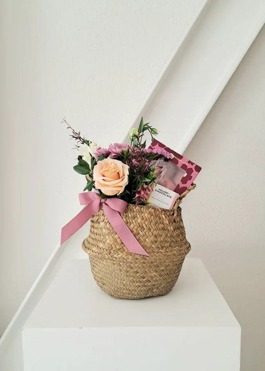 Mother's Day round basket with heart chocolate, blooms, and a notecard.