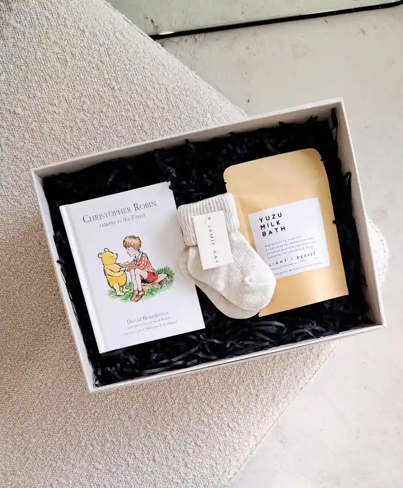 Welcome baby and pamper mum with the Baby + Mum Mini Gift Box, including socks, a book, and more.