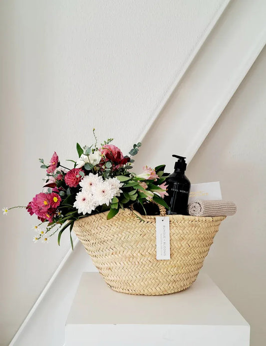 Mother’s Day gift basket with body wash, chocolates, and seasonal flowers.